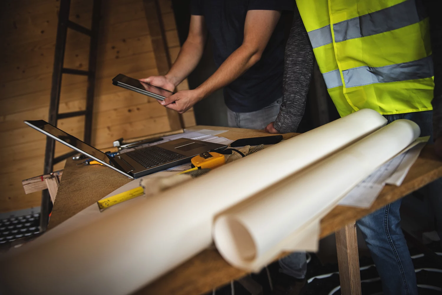 Construction Workers Examining Their Plans On A Laptop